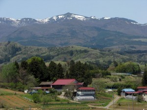新緑の山（手前）と雪の残る安達太良山（奥）